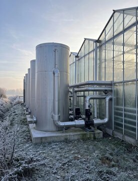 Thermal energy storage tanks supporting greenhouse heating system in cold agricultural region with frost