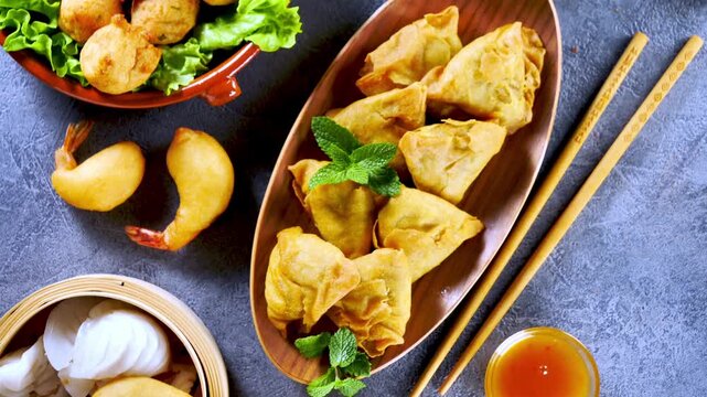 crispy asian appetizers platter with samosas fried shrimp and dim sum with sauce