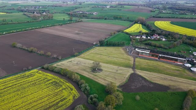 Aerial view of Normandy rural scenery with green landscape, farm fields and quiet village environment.