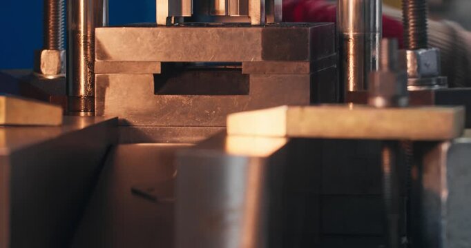 Blanking die working on mechanical stamping press. Close-up of industrial tooling in metal parts manufacturing