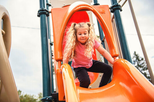 Little girl on a slide outdoors in a park