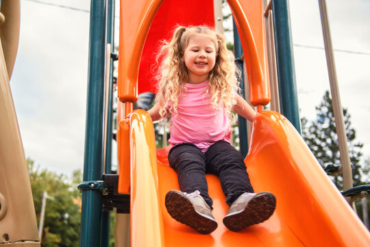 Little girl on a slide outdoors in a park