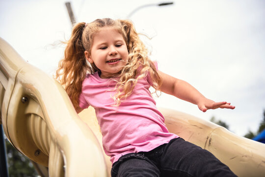 Little girl on a slide outdoors in a park