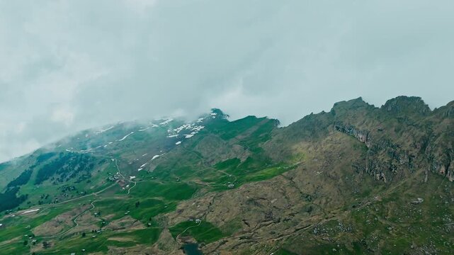 Aerial view of Seceda ridge with green alpine slopes and cloud cover, South Tyrol, Italy