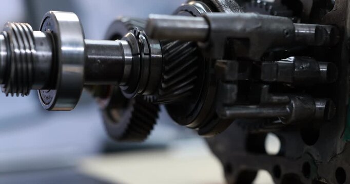 Close-up of metal gears, shafts and bearings inside an industrial machine, precision engineering and mechanical parts in a workshop.