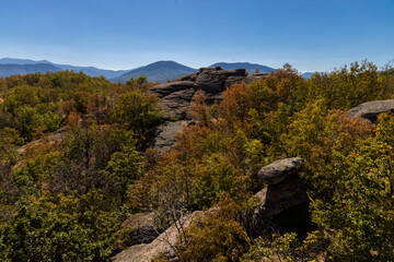 Fototapeta premium Belogradchik Rocks in Bulgaria, a spectacular natural rock formation featuring towering red sandstone and conglomerate cliffs shaped by erosion. The dramatic rock landscape