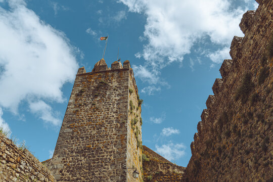 The historic stone keep of Montemor-o-Novo Castle under a blue sky, Portugal