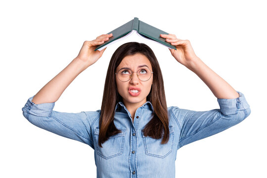 Close up photo of stressed sad girl hold open book above head wear spectacles blue cloth isolated on grey background