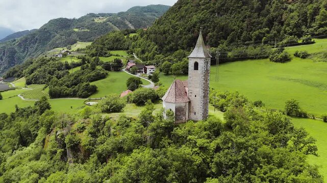 Chiesa di Sant Andrea in Renon with adjacent meadows and rural plots, aerial view. Province of Bolzano, Italy