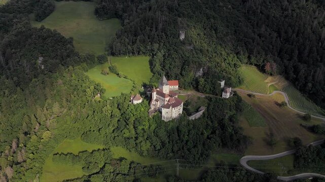 Trostburg Castle dominating green alpine valley with vineyard slopes, South Tyrol Dolomites