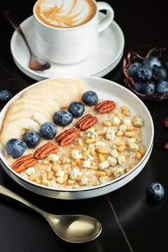 Oatmeal. Bowl of oatmeal porridge with blackberry, bananas and chia seeds on gray concrete old table background. Top view in flat lay style. Natural ingredients. Hot healthy breakfast and diet food