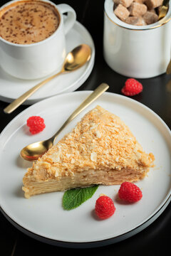 Sliced Napoleon cake on a white wooden table. Classic dessert