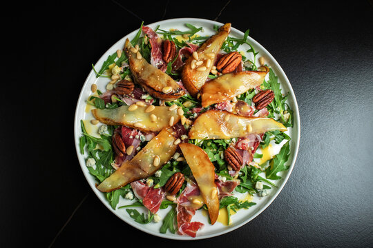 Salad with Pear, Arugula, Jamon, Blue Cheese and Blueberry, Delicious Fresh Salad Appetizer on Bright Background