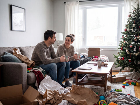 Couple Drinking Coffee on Couch in Living Room After Christmas Morning