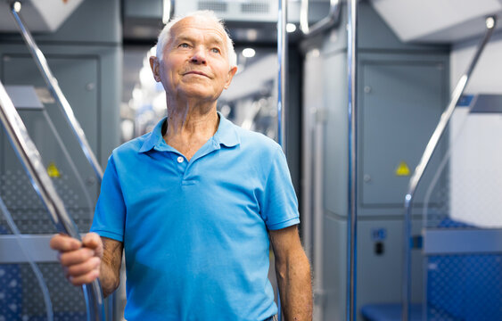 Old man standing in subway car