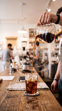 Barista Hand Pouring Cold Brew Coffee with Dynamic Motion Blur in Modern Cafe, Iced Coffee Action Photography with Copy Space