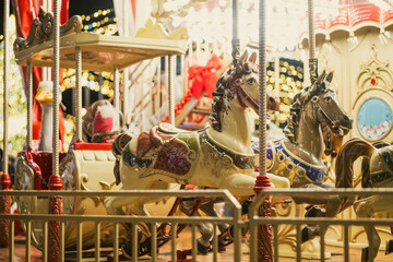 Christmas carousel with colorful animal figures at Cathedral Square in Vilnius, Lithuania. Festive amusement ride and holiday lights create a cheerful winter atmosphere. © MNStudio