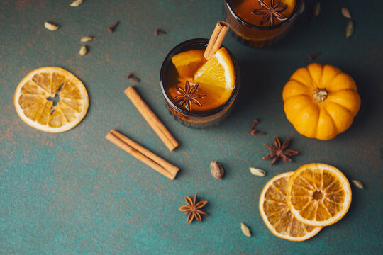 Autumn citrus drinks with cinnamon and star anise on a textured background