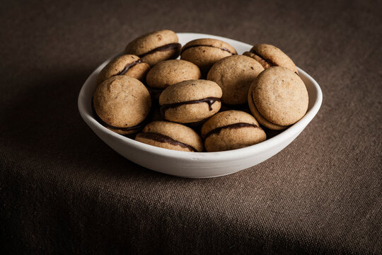 'Baci di dama', shot from the front to highlight their shape and the thin layer of chocolate cream that joins the two halves.
