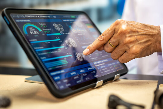 Close-up of a senior person using a touchscreen tablet with financial charts and data, showing digital banking, investing, and technology use.
