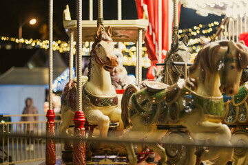 Christmas carousel with colorful animal figures at Cathedral Square in Vilnius, Lithuania. Festive amusement ride and holiday lights create a cheerful winter atmosphere. © MNStudio
