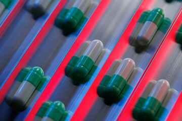 Closeup pharmaceutical production line capsules with AI red laser control quality for manufacturing