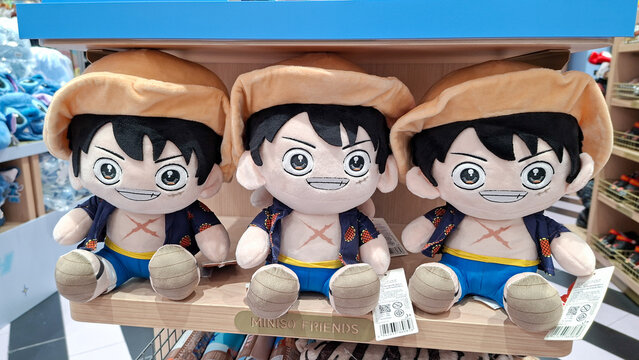 three cute monkey d. luffy plush dolls from one piece wearing straw hat sitting on wooden display on September 16, 2026 in Bangkok, Thailand.