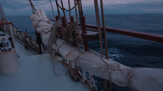 Sailing boat sails in the sea at twilight. Details of the sailing boat