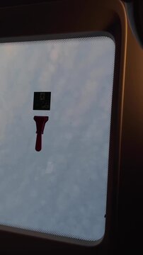 red handled emergency hammer fixed beneath square instruction decal on rectangular skylight opening, shot from inside looking upward at pale glass light tone