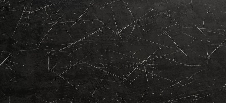 Dark grunge background texture featuring a heavily scratched black surface with white distress marks