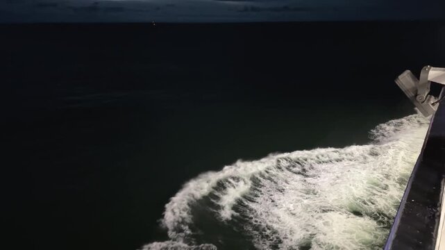 Night view of sea from ship side, waves near hull