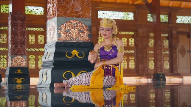 Lonely Javanese Dancer Reflecting While Sitting in Grand Wooden Hall