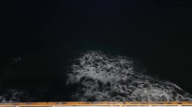 Night view of sea waves near ship hull, top view