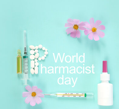 World Pharmacist Day greeting card. syringe, thermometer, flowers and pills on blue abstract background. symbol of medicine, drugs, health care. Flat lay. minimal style