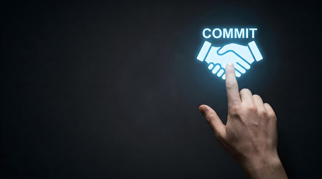 Hand touching a glowing handshake icon with the word commit on a dark background