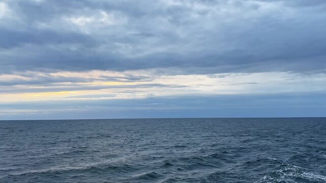 Sea surface with wake from ship at overcast windy morning
