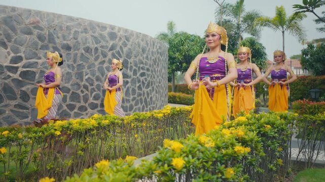 Traditional Dancers Performing Hand Gestures on Garden Walkway