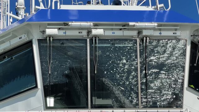 Waves reflection with sun glints on car ferry wheelhouse window