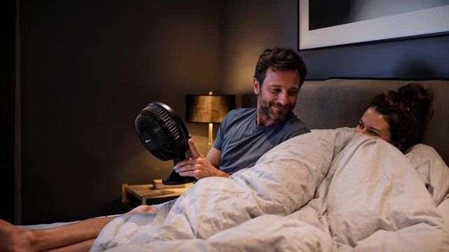 Couple using bedside cooling device in bed at night, personalized sleep comfort concept for temperature regulation and better rest