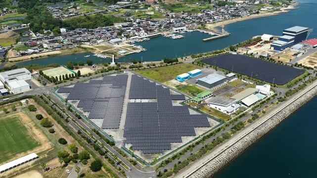 Aerial drone footage of coastal area with solar panels and fishing port in Awaji, Hyogo, Japan