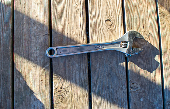 Metal wrench alone on weathered wooden deck