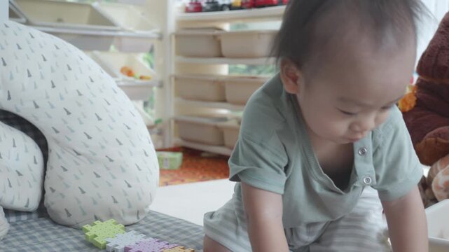 A toddler explores colorful building blocks in a welcoming, cozy play area. The setting encourages creativity and learning through play, providing a safe and stimulating environment for young children