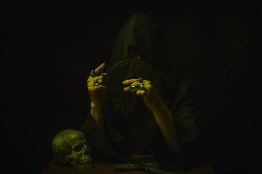 Mysterious hooded cultist with playing cards