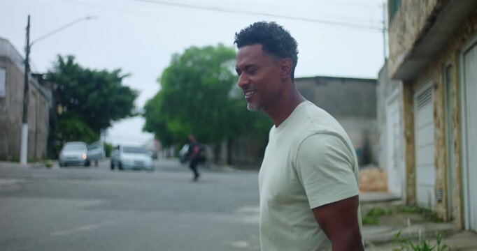 Hispanic Afro-Latin man angrily discussing with someone off camera, expressive gestures, intense conversation, frustration, serious expression, urban street setting, argument