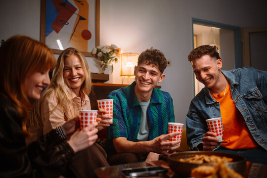 A Group of Friends Having a Great Time Enjoying Snacks and Drinks at a Fun Home Gathering