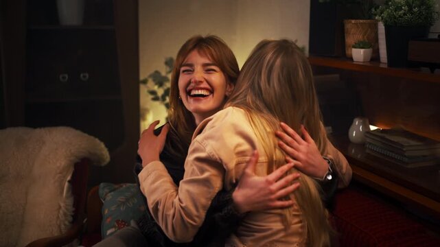 Caucasian Women Joyfully Embrace In Cozy Room Expressing Gratitude And Heartfelt Laughter