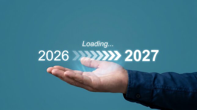Hand holding loading bar transitioning from 2026 to 2027 indicating future progress and year change with blue background and copy space.