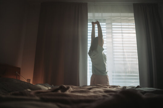 Sunlit Room With Relaxed Atmosphere, Calm Individual Stretches As Morning Light Softly Enters Space
