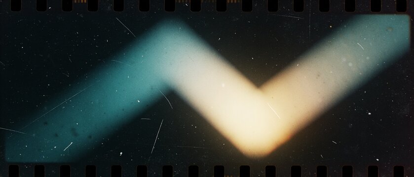 Abstract blurred light streaks forming a V shape on a dark film strip background