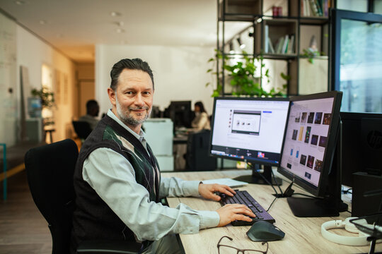 Portrait of mature man working at computer in modern office